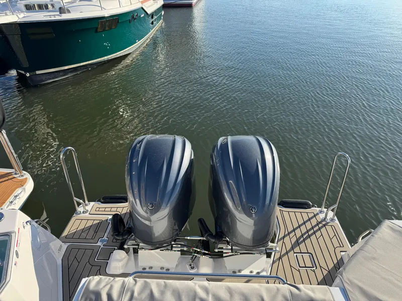Slide: The Image of 2025 Cutwater C-288 Coupe with dual outboard engines docked on calm water. - 8