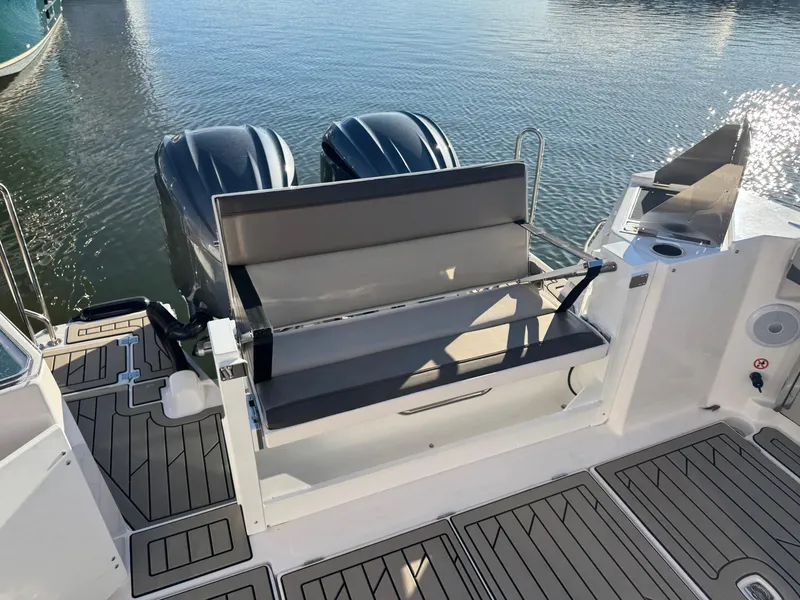 Slide: The Image of 2025 Cutwater C-288 Coupe boat with dual engines and seating, docked on calm water. - 9