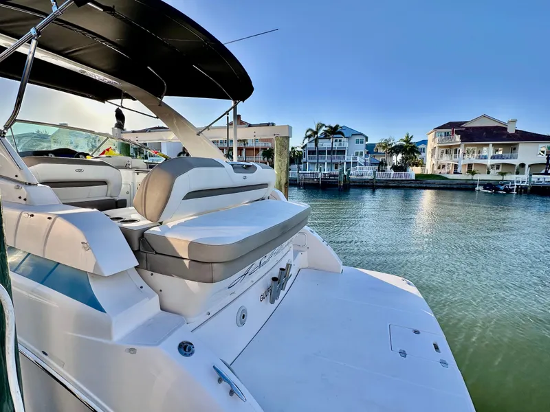 Slide: The Image of 2017 Regal 32 Express boat docked by waterfront homes under clear blue sky. - 11