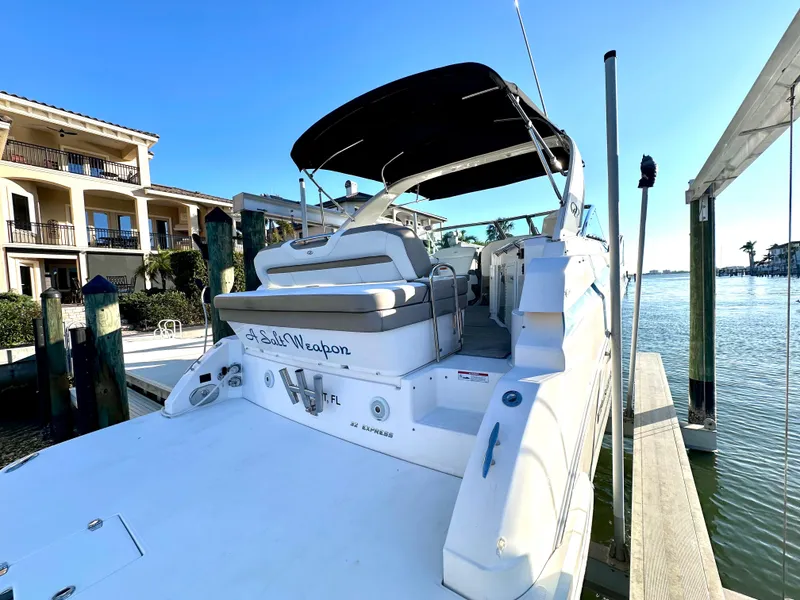 Slide: The Image of 2017 Regal 32 Express boat docked by waterfront homes under clear skies. - 12