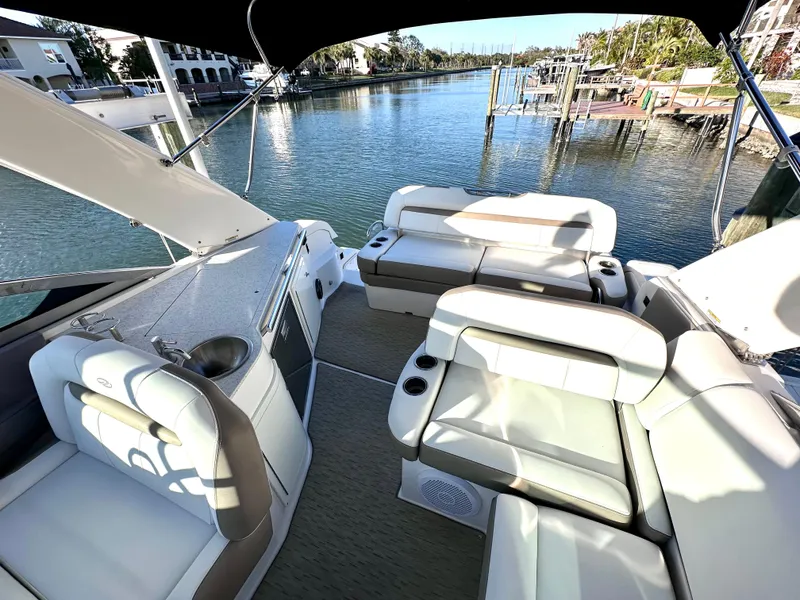 Slide: The Image of 2017 Regal 32 Express boat interior with seating, overlooking a serene waterfront. - 24