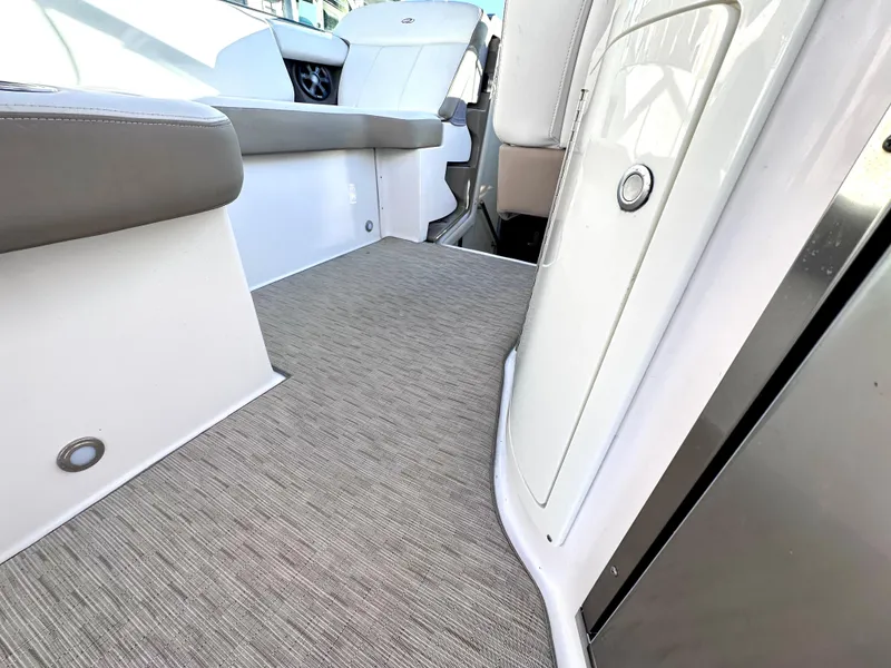 Slide: The Image of 2017 Regal 32 Express boat interior with beige carpet and white seating. - 25