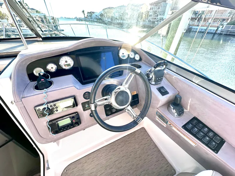 Slide: The Image of 2017 Regal 32 Express boat cockpit with steering wheel, gauges, and navigation controls. - 27