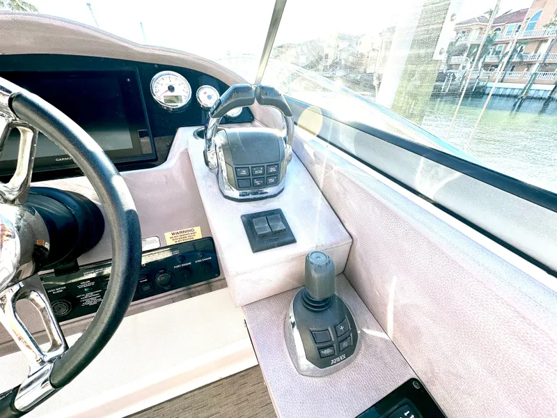 Slide: The Image of Control panel of a 2017 Regal 32 Express boat with steering wheel and throttle. - 29