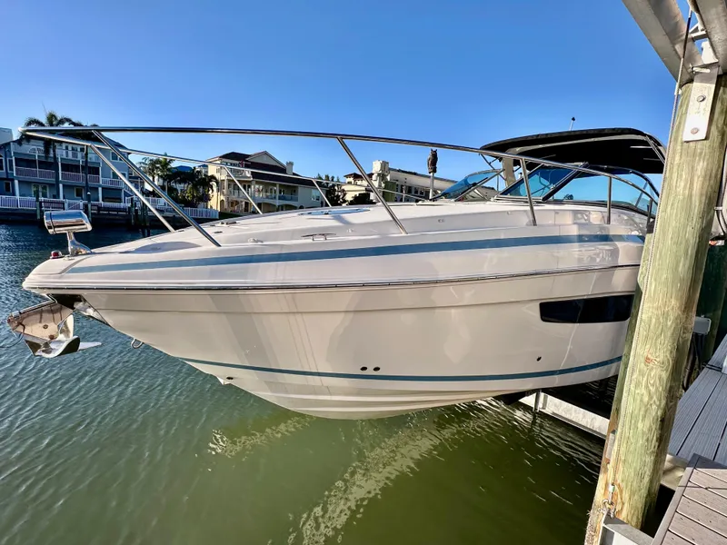 Slide: The Image of 2017 Regal 32 Express boat docked in a marina, surrounded by waterfront homes. - 3
