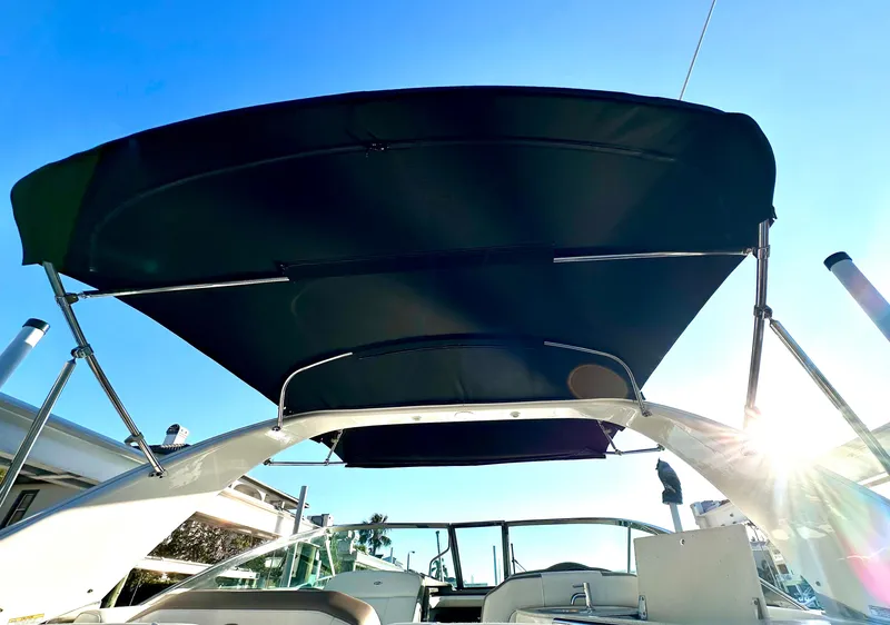 Slide: The Image of 2017 Regal 32 Express boat with sunshade, viewed from the deck under clear blue sky. - 31