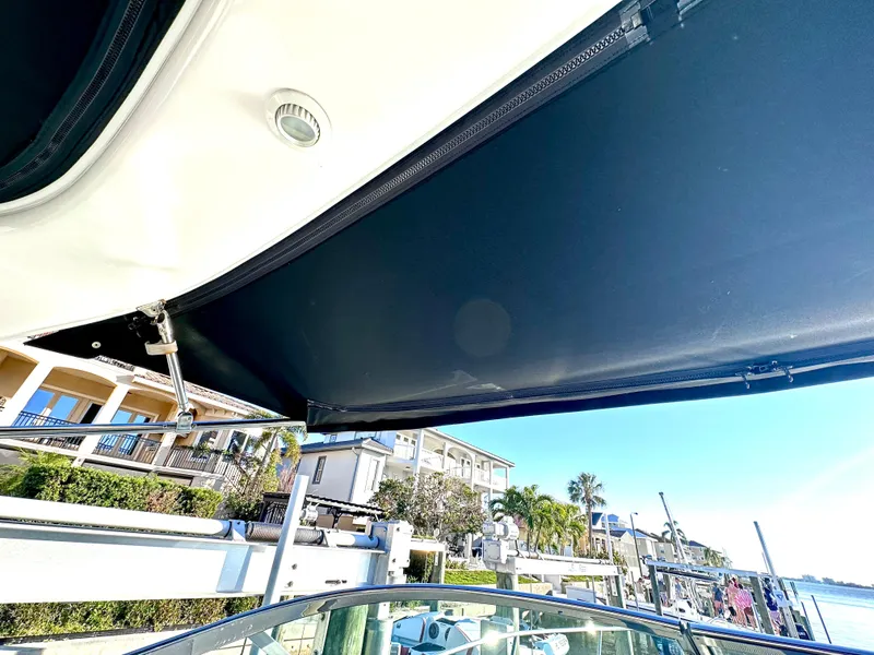 Slide: The Image of 2017 Regal 32 Express boat with sunshade, docked near waterfront homes. - 33