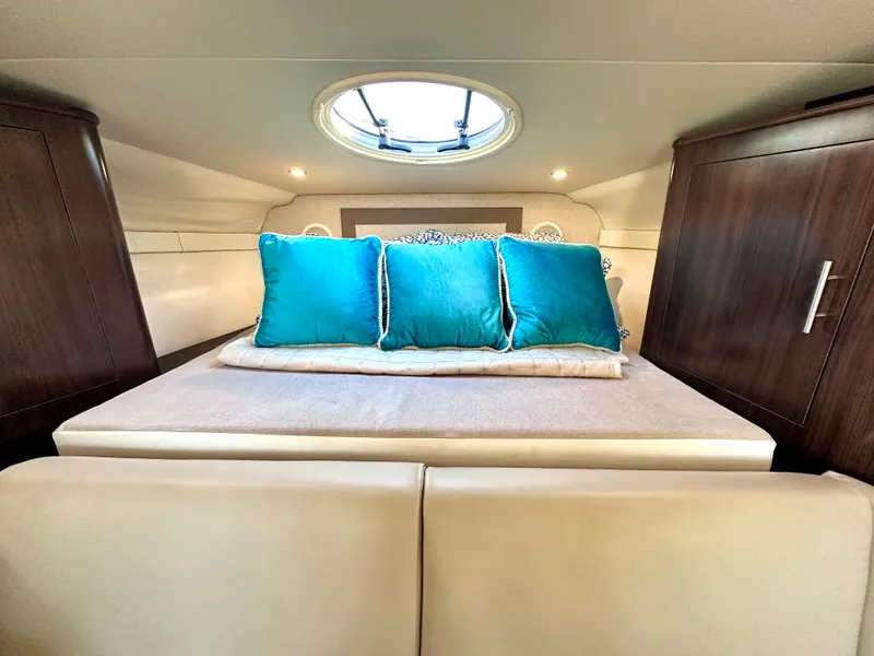 Slide: The Image of 2017 Regal 32 Express cabin interior with teal pillows and skylight. - 38