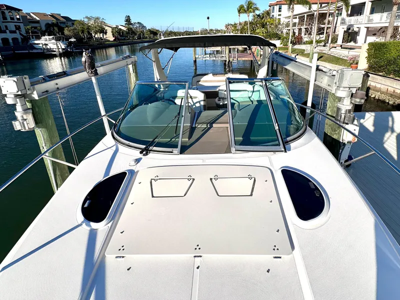 Slide: The Image of 2017 Regal 32 Express boat docked in a sunny marina, showcasing sleek design and spacious deck. - 4