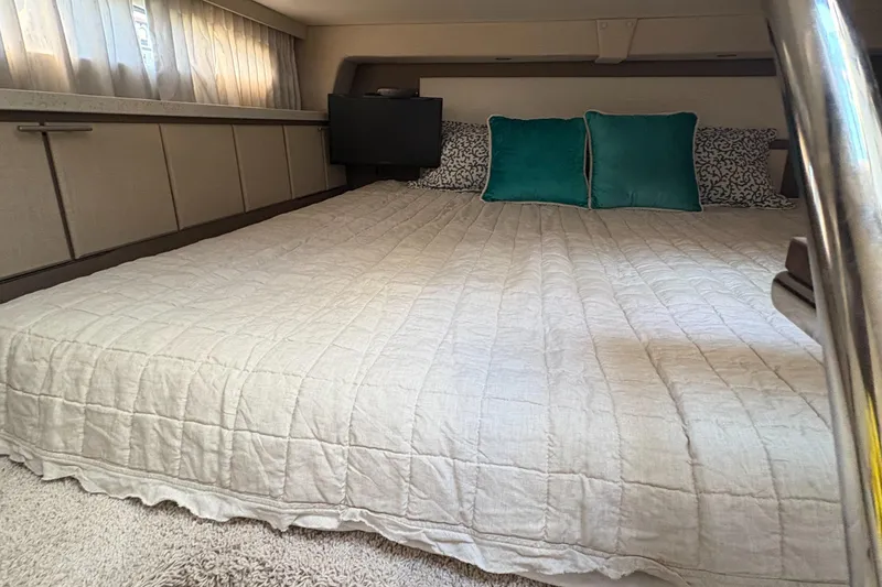 Slide: The Image of Interior cabin of 2017 Regal 32 Express with bed and teal pillows. - 45