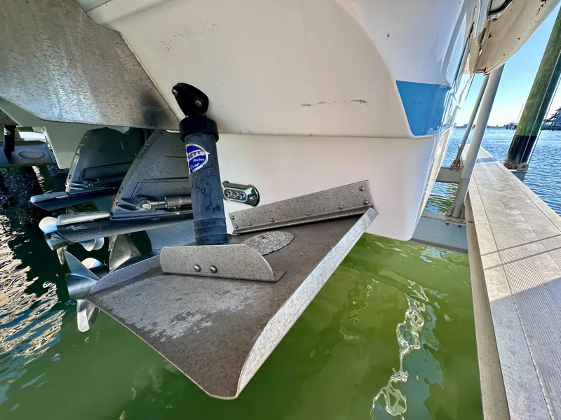 Slide: The Image of 2017 Regal 32 Express boat stern with trim tab and propeller in water. - 48