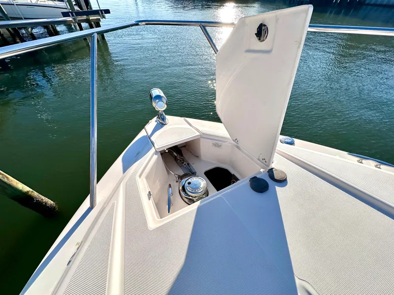 Slide: The Image of Bow of 2017 Regal 32 Express boat with open anchor locker, docked on calm water. - 7