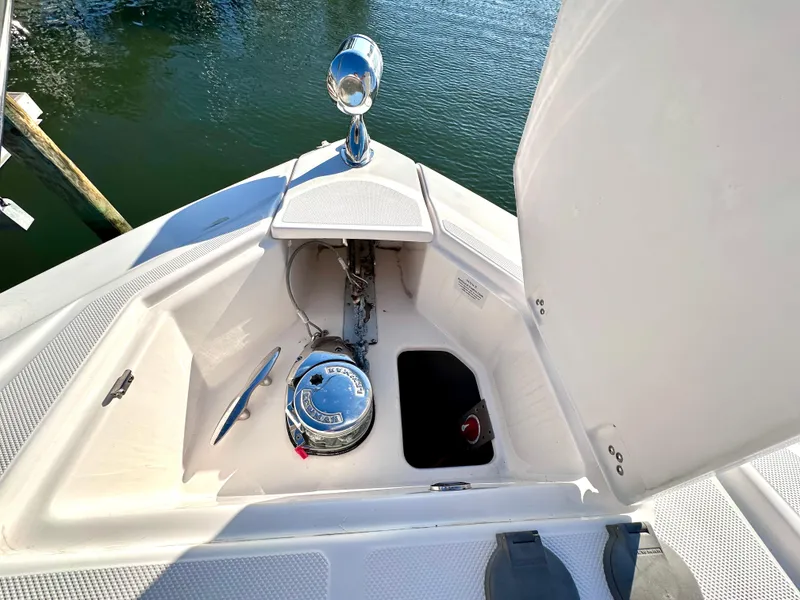Slide: The Image of 2017 Regal 32 Express boat anchor compartment with open hatch, docked on calm water. - 8