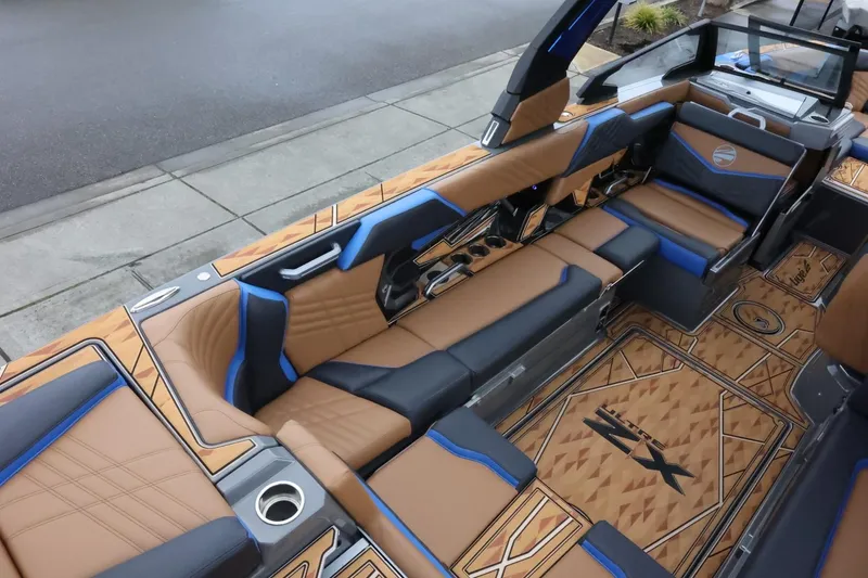Slide: The Image of 2025 Tigé Ultré 25ZX boat interior with luxurious tan and blue seating, stylish design. - 12