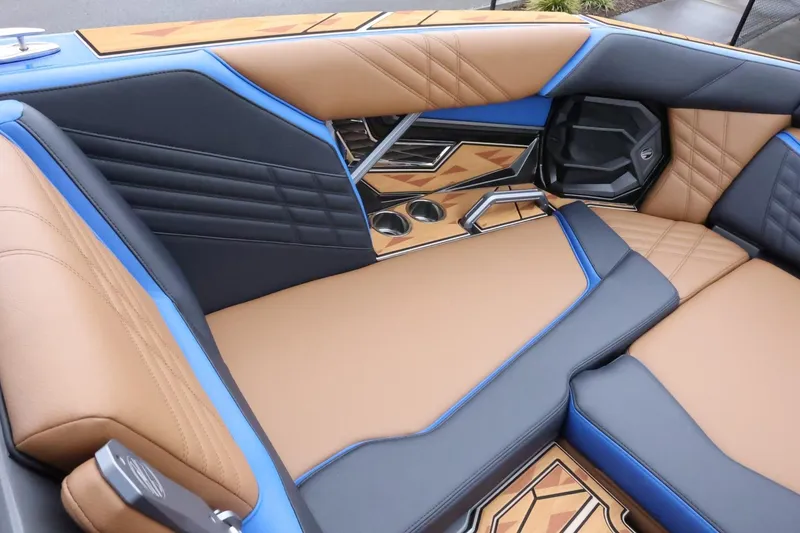 Slide: The Image of 2025 Tigé Ultré 25ZX boat interior with luxurious tan and blue seating, modern design. - 18