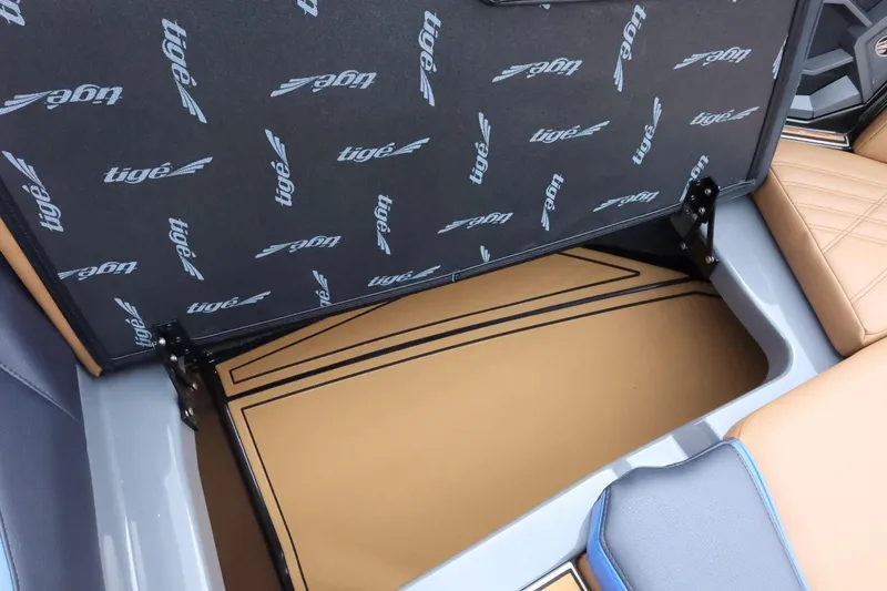 Slide: The Image of 2025 Tigé Ultré 25ZX boat storage compartment with branded interior design. - 20