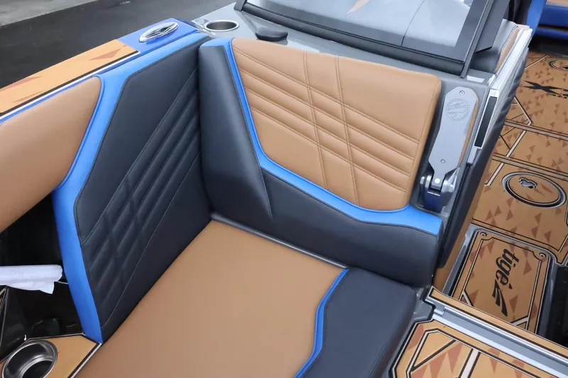 Slide: The Image of 2025 Tigé Ultré 25ZX boat interior with tan and blue upholstery, featuring modern design elements. - 24