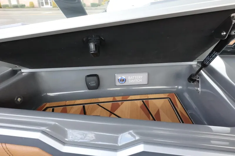Slide: The Image of 2025 Tigé Ultré 25ZX battery compartment with switch, open lid, and wood paneling. - 42