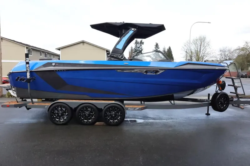 Slide: The Image of 2025 Tigé Ultré 25ZX boat in vibrant blue on a trailer, parked outdoors. - 5