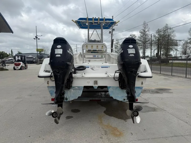 Slide: The Image of 2005 Twin Vee 26 Center Console boat with dual outboard motors, parked outdoors. - 3