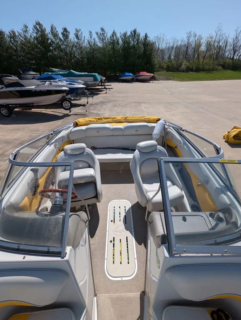 Slide: The Image of 2006 Crownline 180 BR boat with yellow and white interior, parked outdoors. - 4