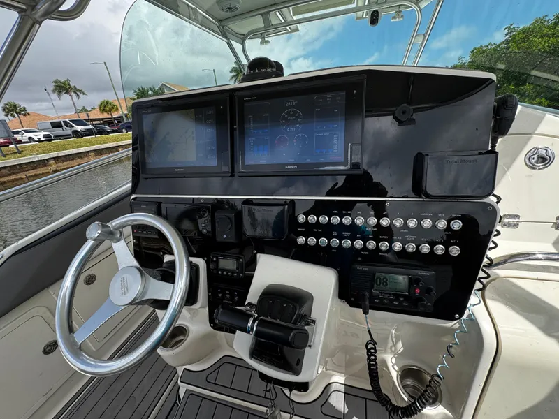 Slide: The Image of Control panel of a 2005 Hydra-Sports 3300 VX boat with steering wheel and navigation screens. - 17