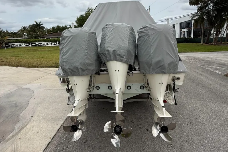 Slide: The Image of 2005 Hydra-Sports 3300 VX boat with triple outboard motors covered, parked on a driveway. - 37