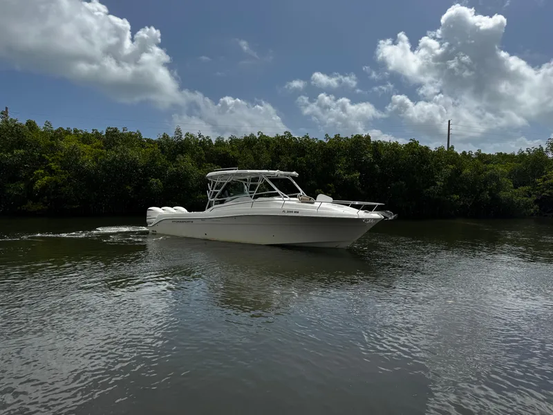 Slide: The Image of 2005 Hydra-Sports 3300 VX boat cruising on a calm river under a cloudy sky. - 7