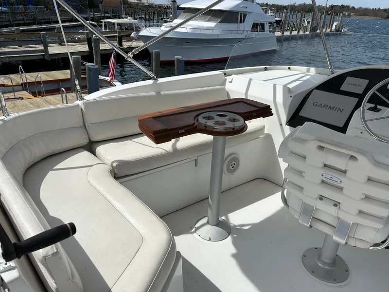 Slide: The Image of 2006 Beneteau 42 Swift Trawler cockpit with seating, table, and Garmin navigation system. - 12
