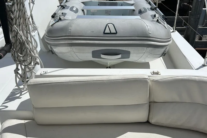 Slide: The Image of 2006 Beneteau 42 Swift Trawler with inflatable dinghy on deck, white seating visible. - 17