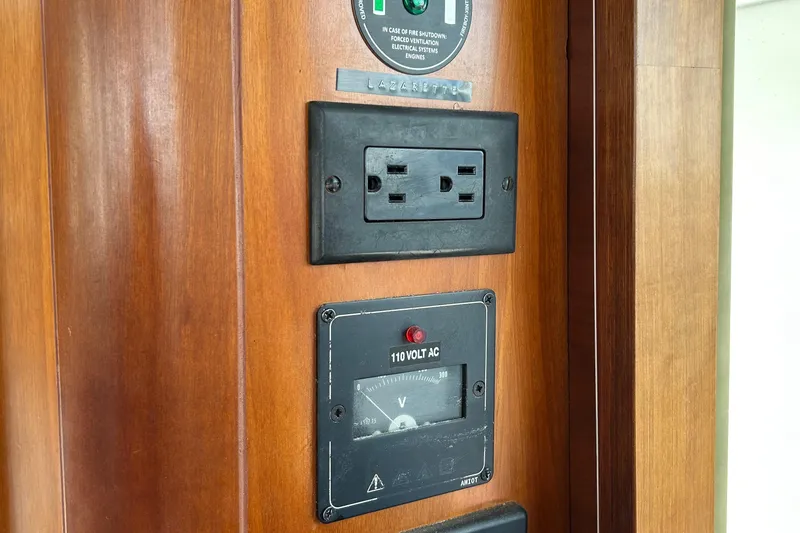 Slide: The Image of Electrical outlet and voltage meter on 2006 Beneteau 42 Swift Trawler wooden panel. - 23