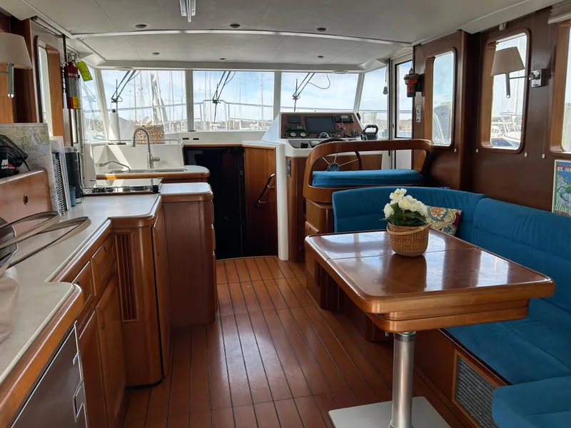 Slide: The Image of Interior of 2006 Beneteau 42 Swift Trawler with wood finish and blue seating. - 24