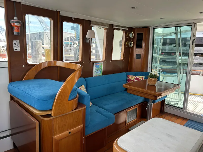 Slide: The Image of Interior of 2006 Beneteau 42 Swift Trawler with blue seating and wooden accents. - 25