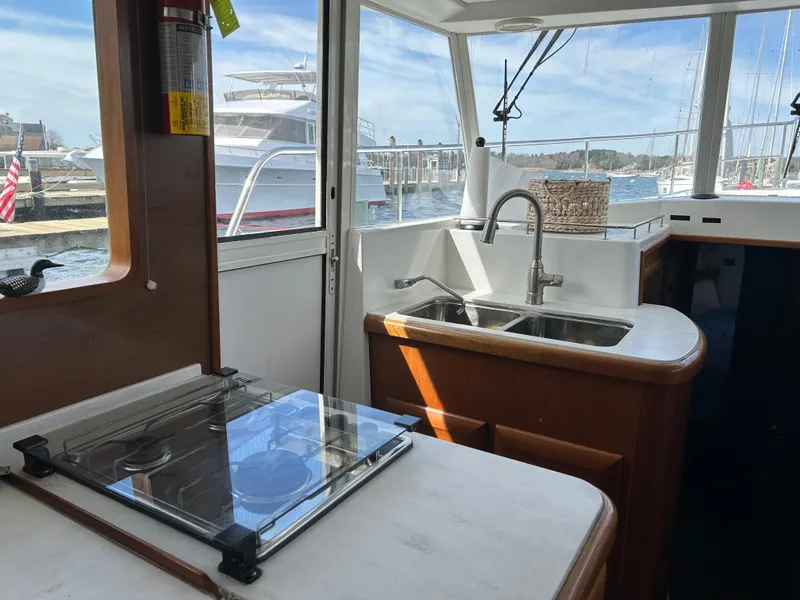 Slide: The Image of Interior of 2006 Beneteau 42 Swift Trawler kitchen with sink and stove, docked at marina. - 30