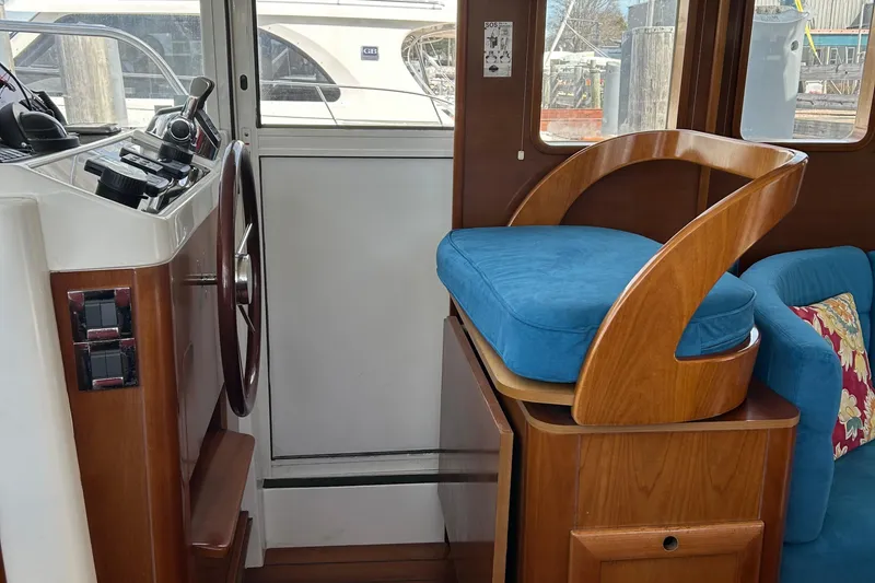 Slide: The Image of Interior of 2006 Beneteau 42 Swift Trawler with helm and blue cushioned seat. - 34