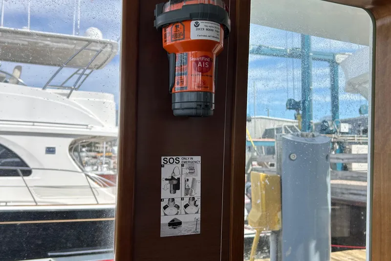 Slide: The Image of Orange emergency beacon and SOS instructions on a 2006 Beneteau 42 Swift Trawler. - 35