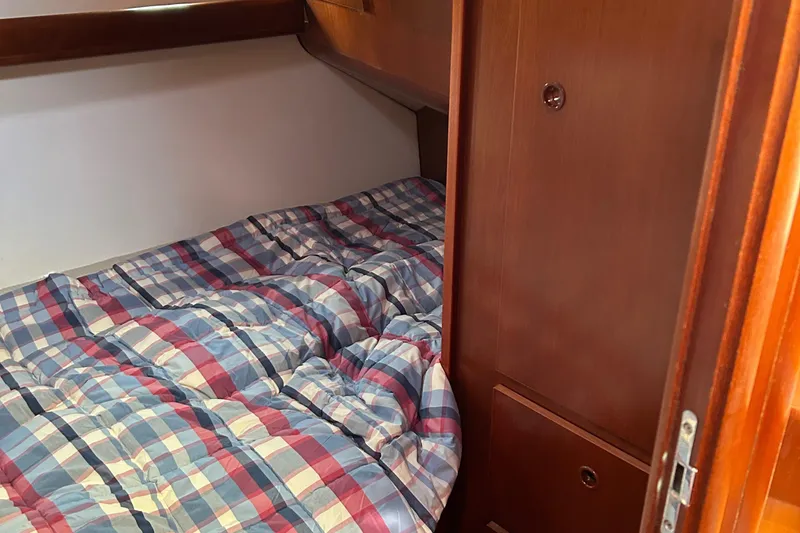 Slide: The Image of Cozy cabin bed in 2006 Beneteau 42 Swift Trawler with plaid bedding. - 44