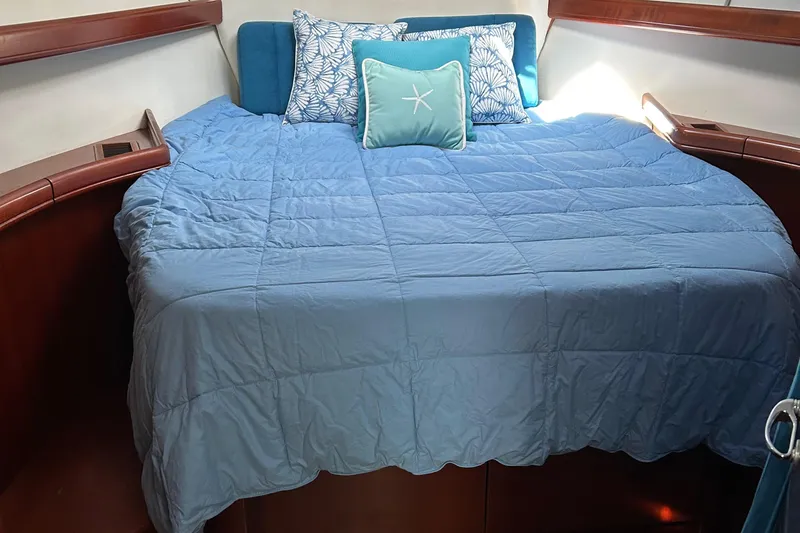 Slide: The Image of Cozy cabin bed in 2006 Beneteau 42 Swift Trawler with blue bedding and decorative pillows. - 46