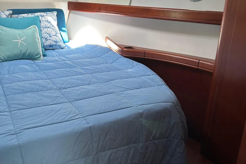 Slide: The Image of Cozy bedroom in 2006 Beneteau 42 Swift Trawler with blue bedding and decorative pillows. - 47