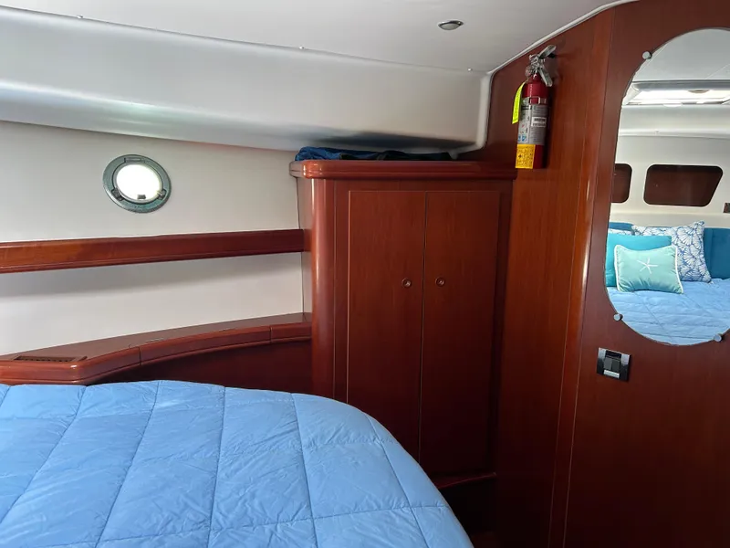 Slide: The Image of Cabin interior of 2006 Beneteau 42 Swift Trawler with wood finish and blue bedding. - 48