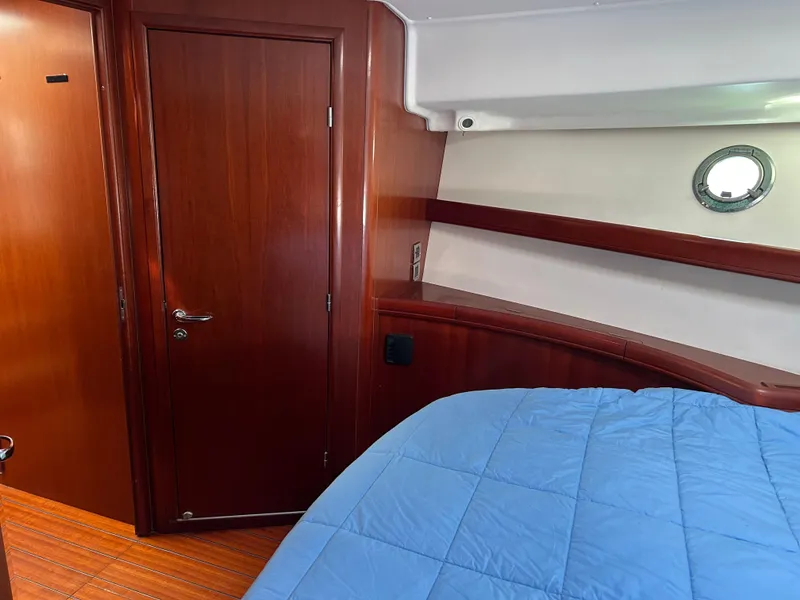 Slide: The Image of Interior cabin of 2006 Beneteau 42 Swift Trawler with wood finish and blue bedding. - 49