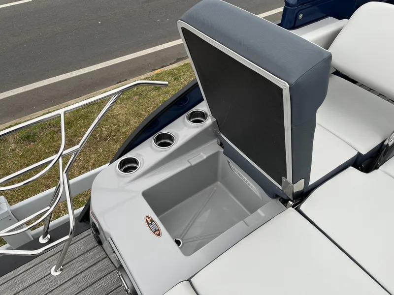 Slide: The Image of 2025 Harris Grand Mariner 250 boat seating with built-in cup holders and storage compartment. - 13