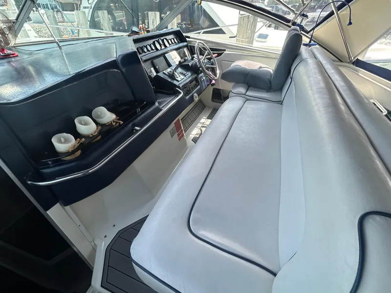 Slide: The Image of 1990 Sea Ray 350 Sundancer interior with white seating and dashboard view. - 13