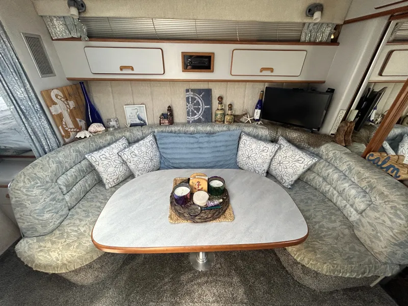 Slide: The Image of Cozy interior of 1990 Sea Ray 350 Sundancer with plush seating and decorative accents. - 19