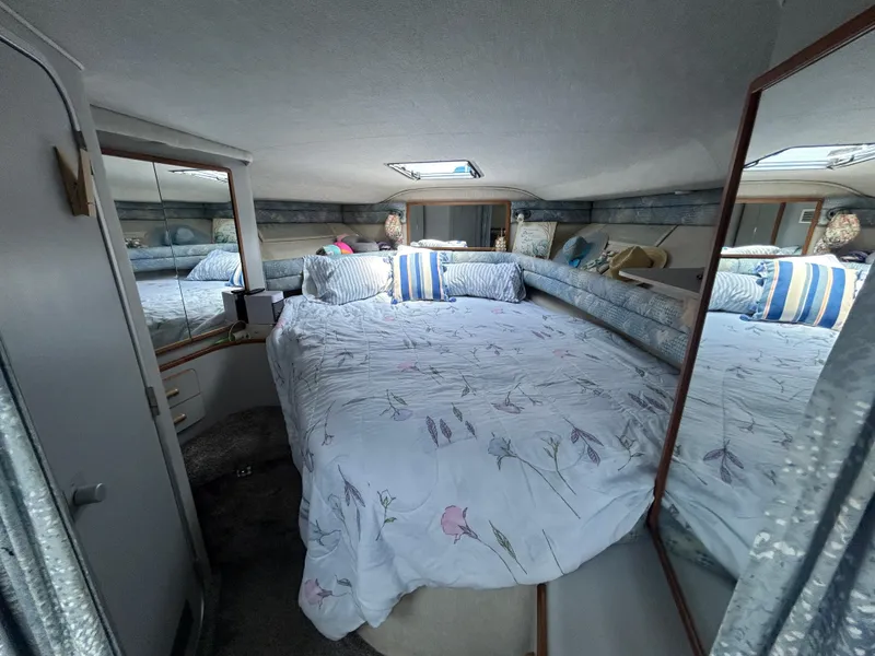 Slide: The Image of Cozy cabin interior of 1990 Sea Ray 350 Sundancer with bed and mirrors. - 22