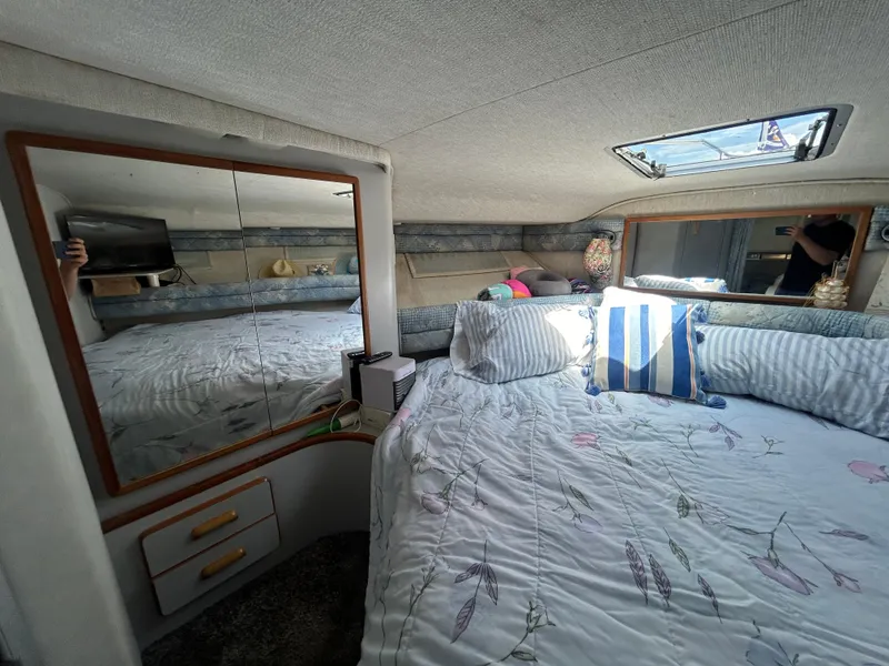 Slide: The Image of Cozy cabin interior of a 1990 Sea Ray 350 Sundancer with bed and mirrored storage. - 24