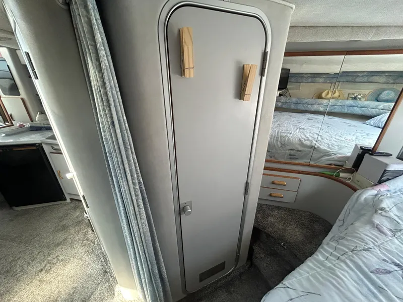 Slide: The Image of Interior of 1990 Sea Ray 350 Sundancer showing cabin door and cozy sleeping area. - 25