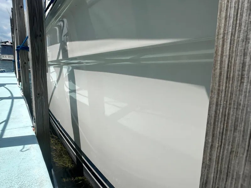 Slide: The Image of Side view of a 1990 Sea Ray 350 Sundancer boat docked. - 7