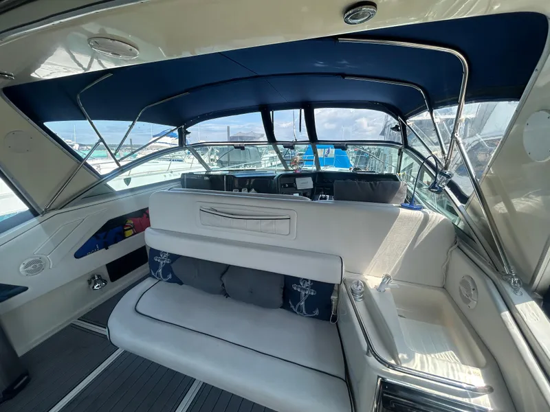 Slide: The Image of 1990 Sea Ray 350 Sundancer interior with blue canopy and cushioned seating. - 8