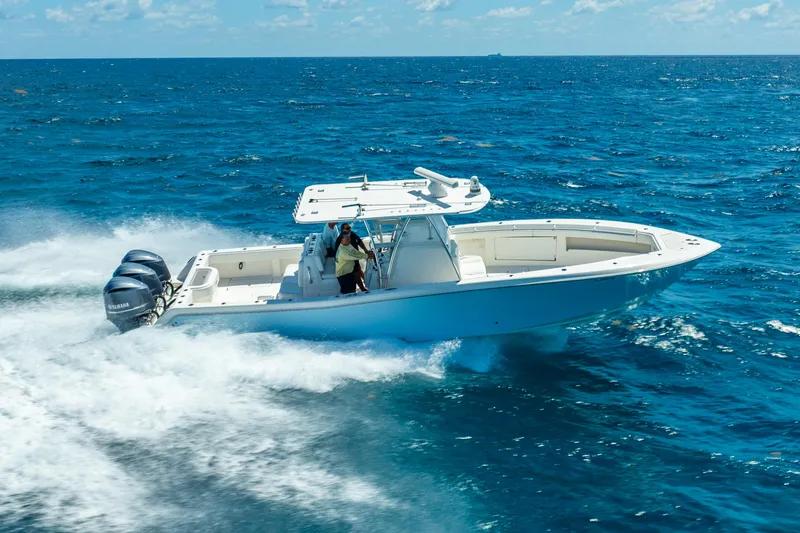 Slide: The Image of 2016 Invincible 39 boat cruising on open ocean with triple outboard engines. - 10
